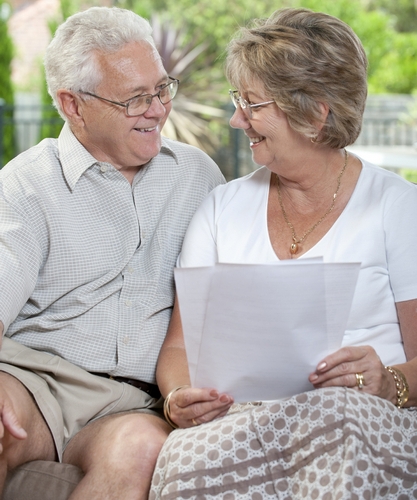 Elderly couple talking  and smiling looking at a document